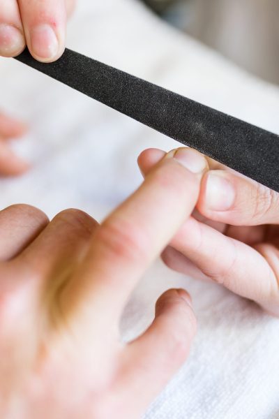 Portrait of young man doing manicure in salon. Beauty concept.
